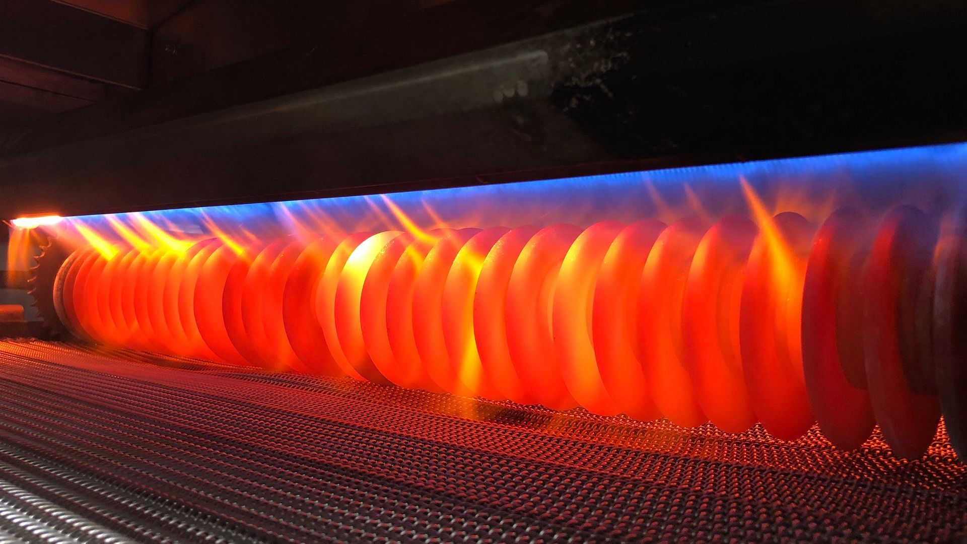 A close up of a stove with flames coming out of it.