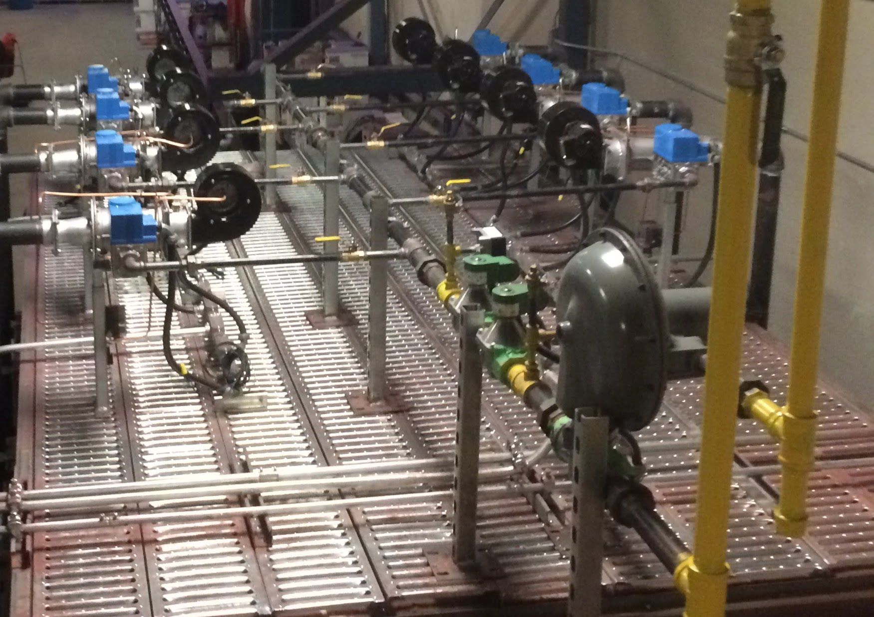 A bunch of pipes are lined up on a metal floor