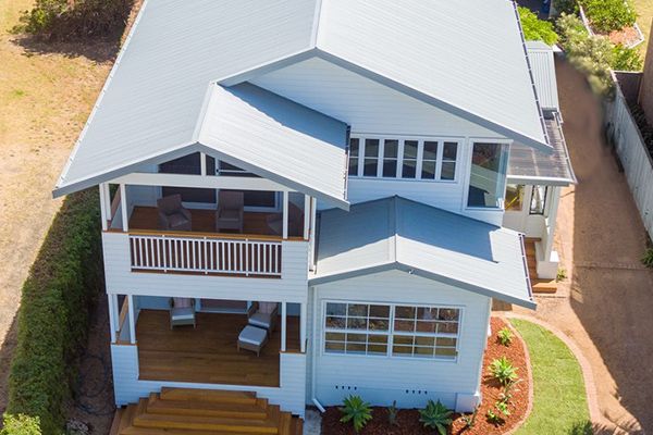 An Aerial View of a Large White House With a Blue Roof — Sheps Roofing Service Pty Ltd In Wollongong, NSW