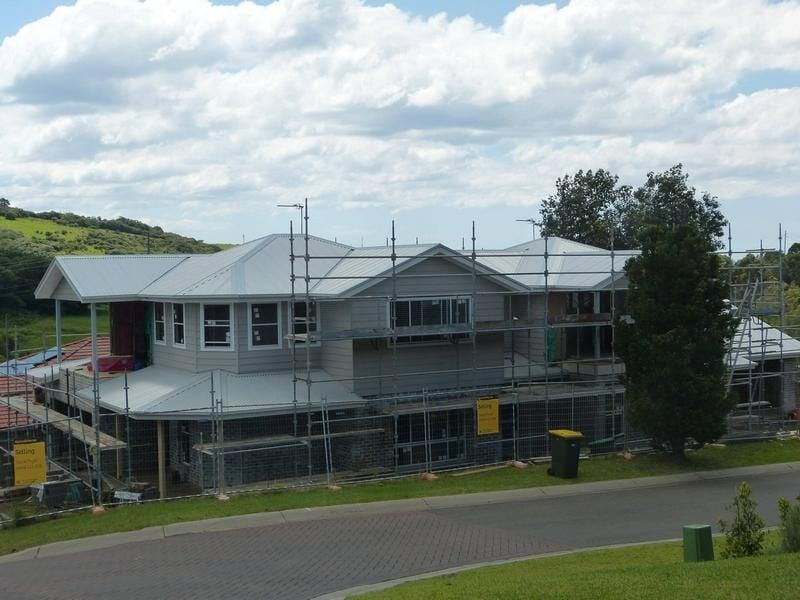 A Large House Under Construction With Scaffolding Around It — Sheps Roofing Service Pty Ltd In Albion Park Rail, NSW