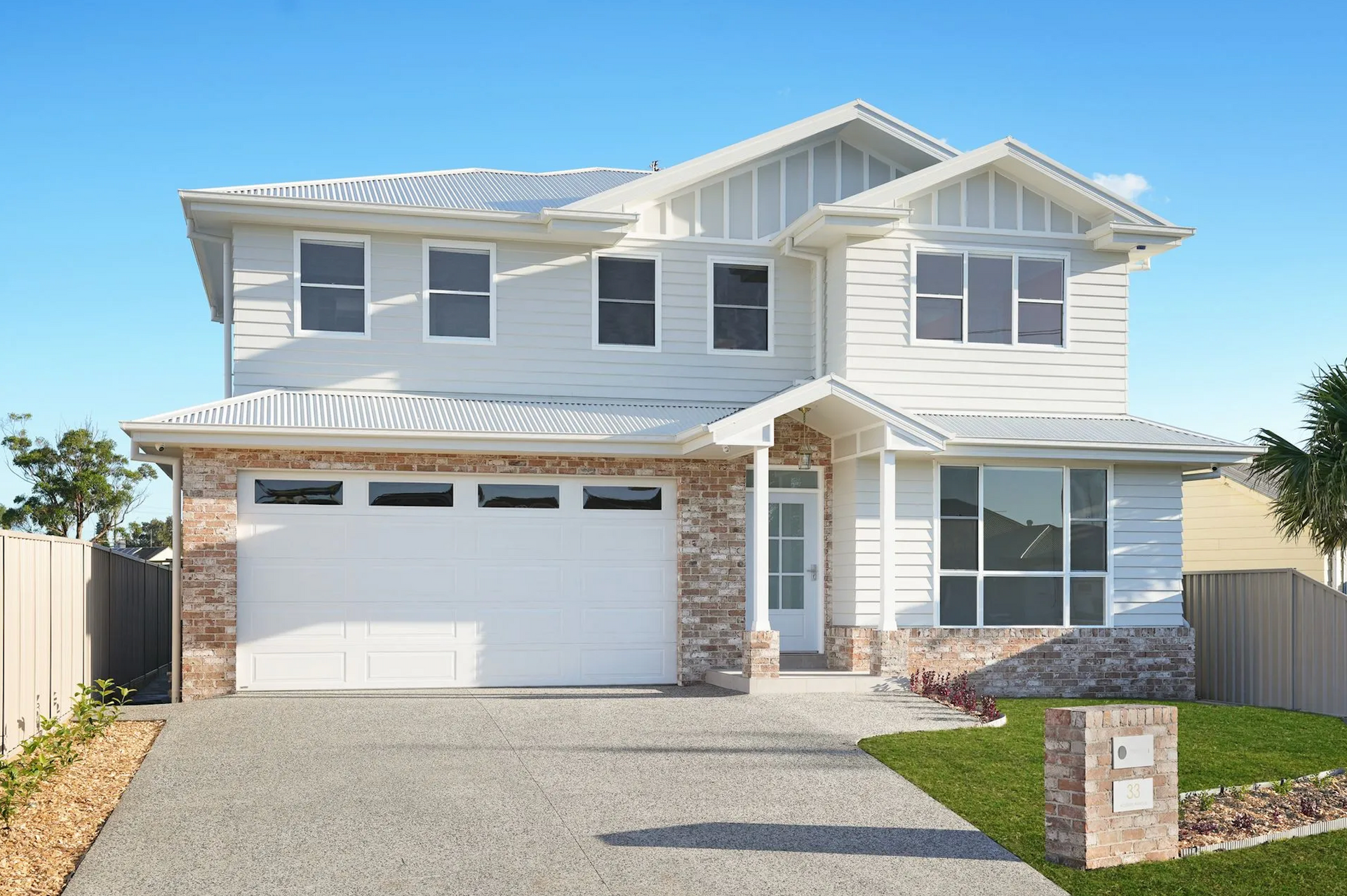 A White House With a Brown Garage Door — Sheps Roofing Service Pty Ltd In Albion Park Rail, NSW