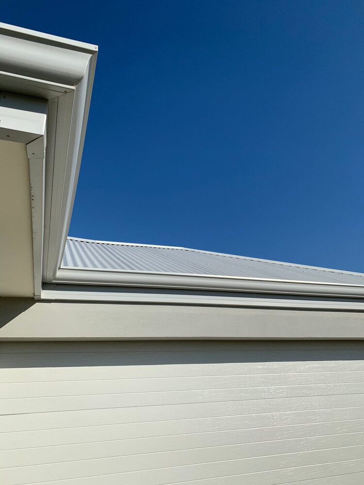 The Roof of a White House With a Blue Sky in the Background — Sheps Roofing Service Pty Ltd In Albion Park, NSW