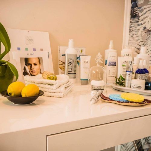 Spa-Theke mit Hautpflegeprodukten, Zitronen, Handtüchern und einer Orchidee.