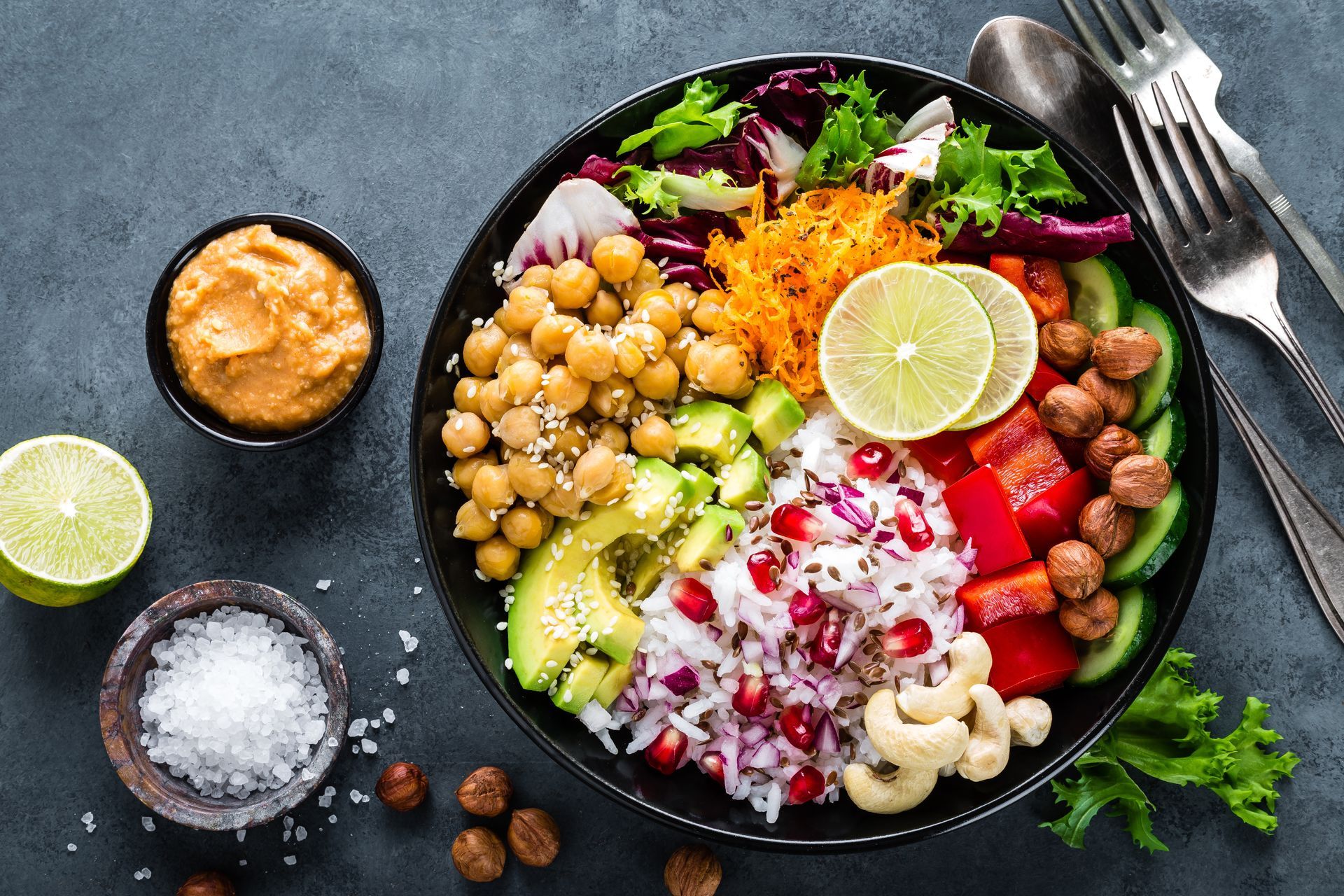 Colorful Buddha bowl with chickpeas, avocado, vegetables, and hummus.