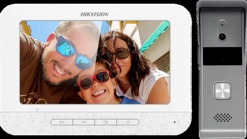 White video intercom display showing a smiling family. Gray door station next to the display.