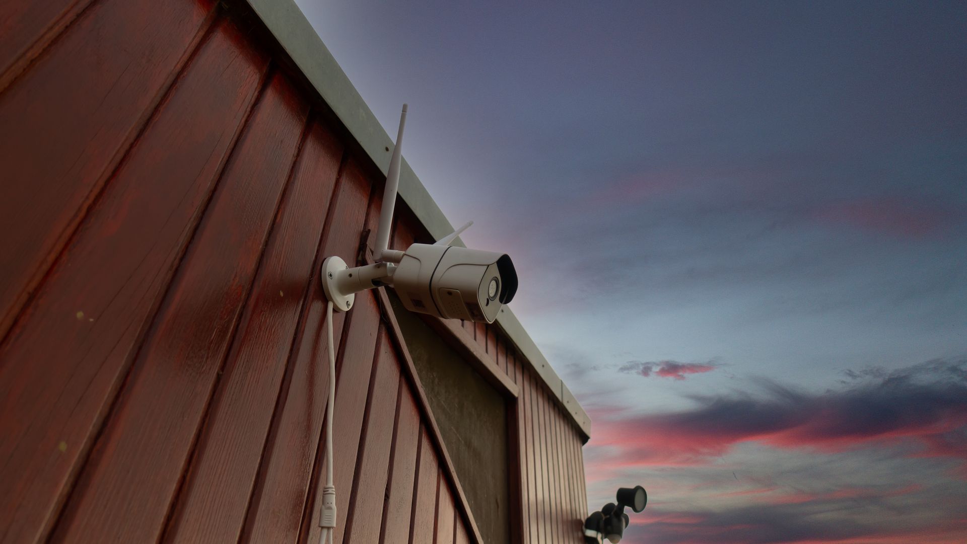 Wide exterior shot of a completed commercial install — shopfront or warehouse, multiple cameras visible in one frame. Wide exterior shot of a completed commercial install — shopfront or warehouse, multiple cameras visible in one frame.
