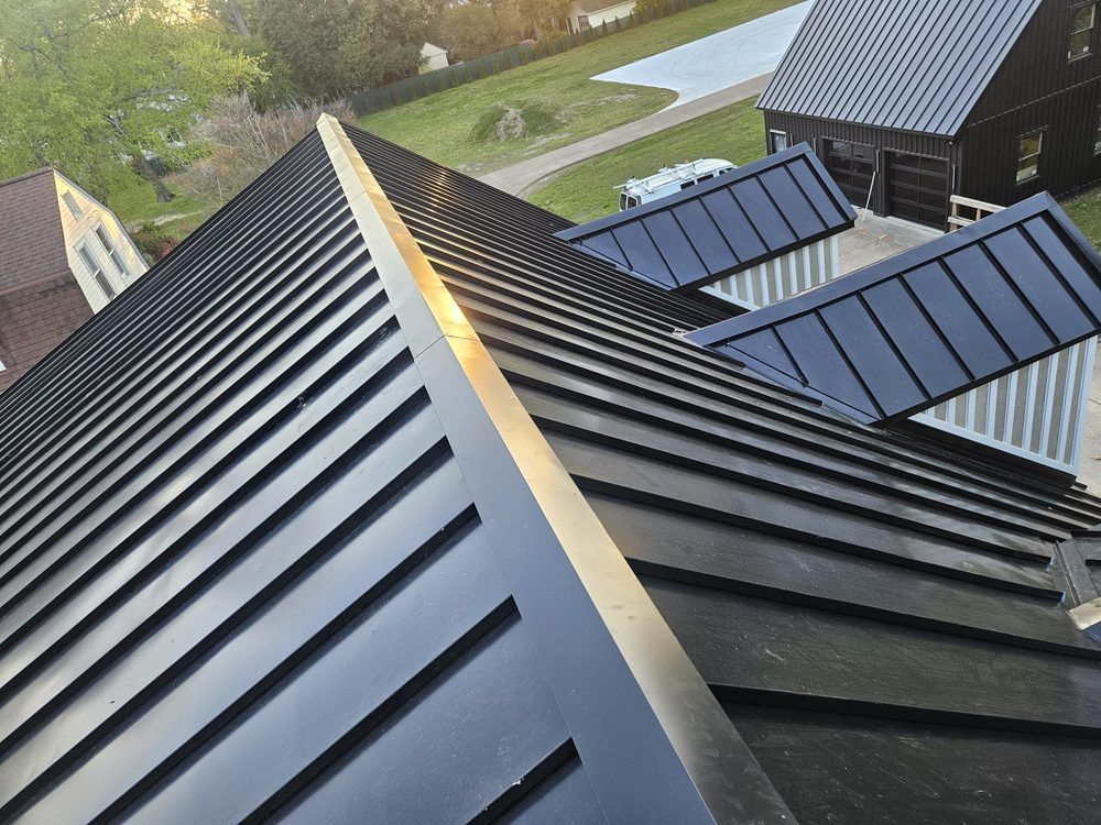 Black metal rooftop with solar panels and a sunny outdoor view