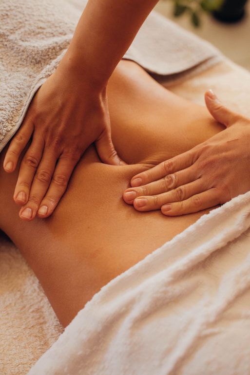 Hands performing a therapeutic massage on a person's midsection, set in a calm, professional environment.