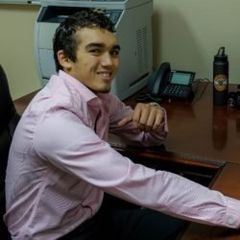 AUSTIN CLARK Austin Clark, sitting at a desk.