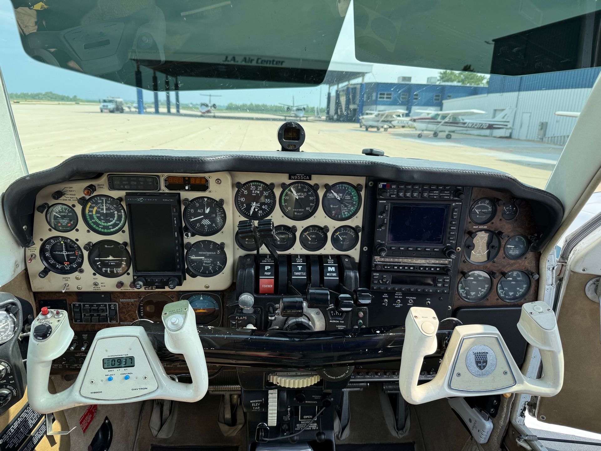Cockpit of a Beechcraft Baron with dual yokes and analog flight instruments on the ramp at JA Air Center.