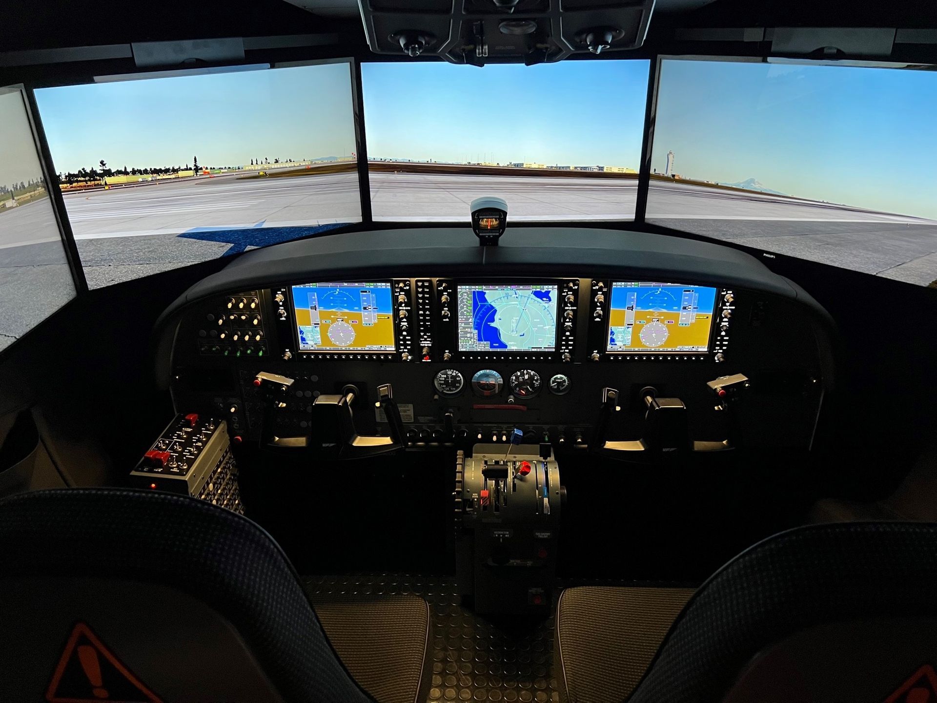 Full-motion Cessna Caravan flight simulator with multi-screen visuals and glass cockpit displays.