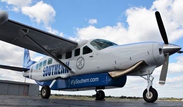 Cessna Caravan aircraft with Southern branding parked on ramp under partly cloudy sky.