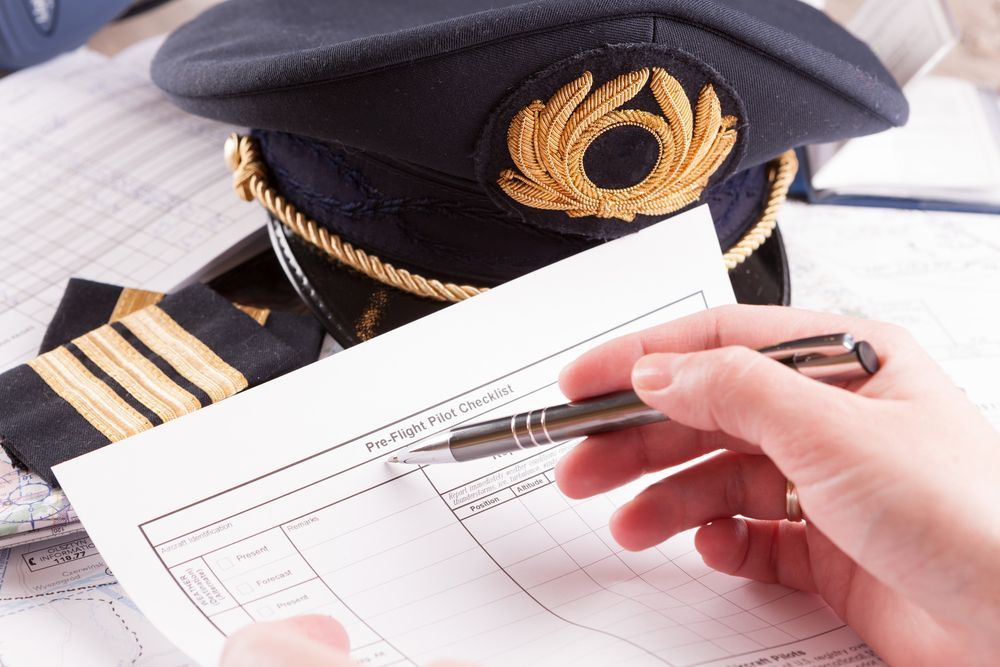Someone is filling out a pre-flight pilot checklist.