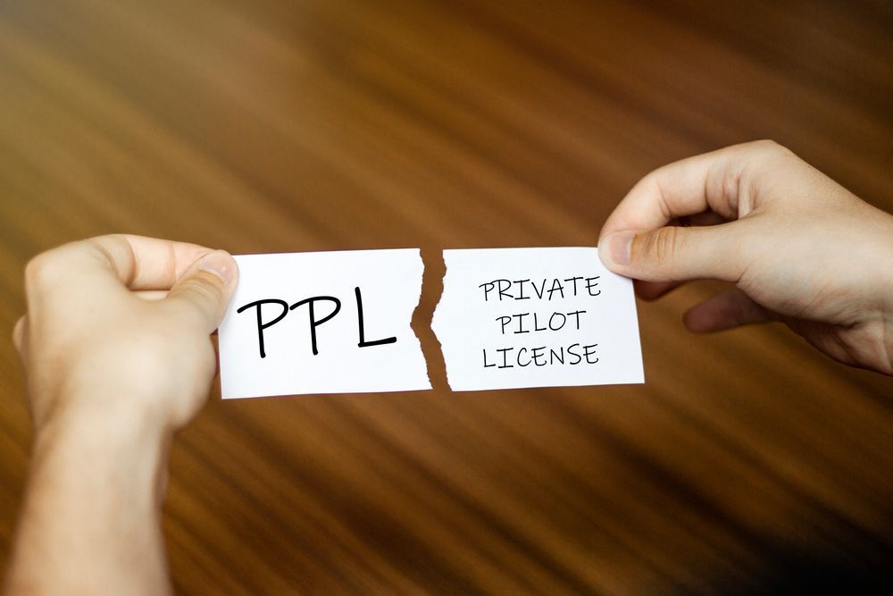 Hands holding torn paper reading PPL—Private Pilot License.