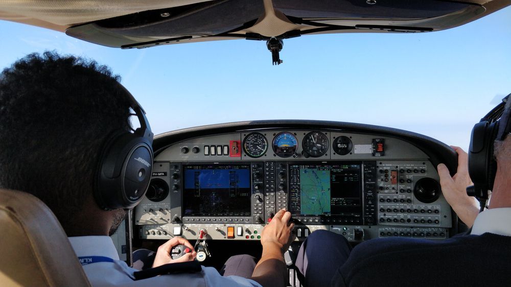 Two pilots are sitting in the cockpit of an airplane