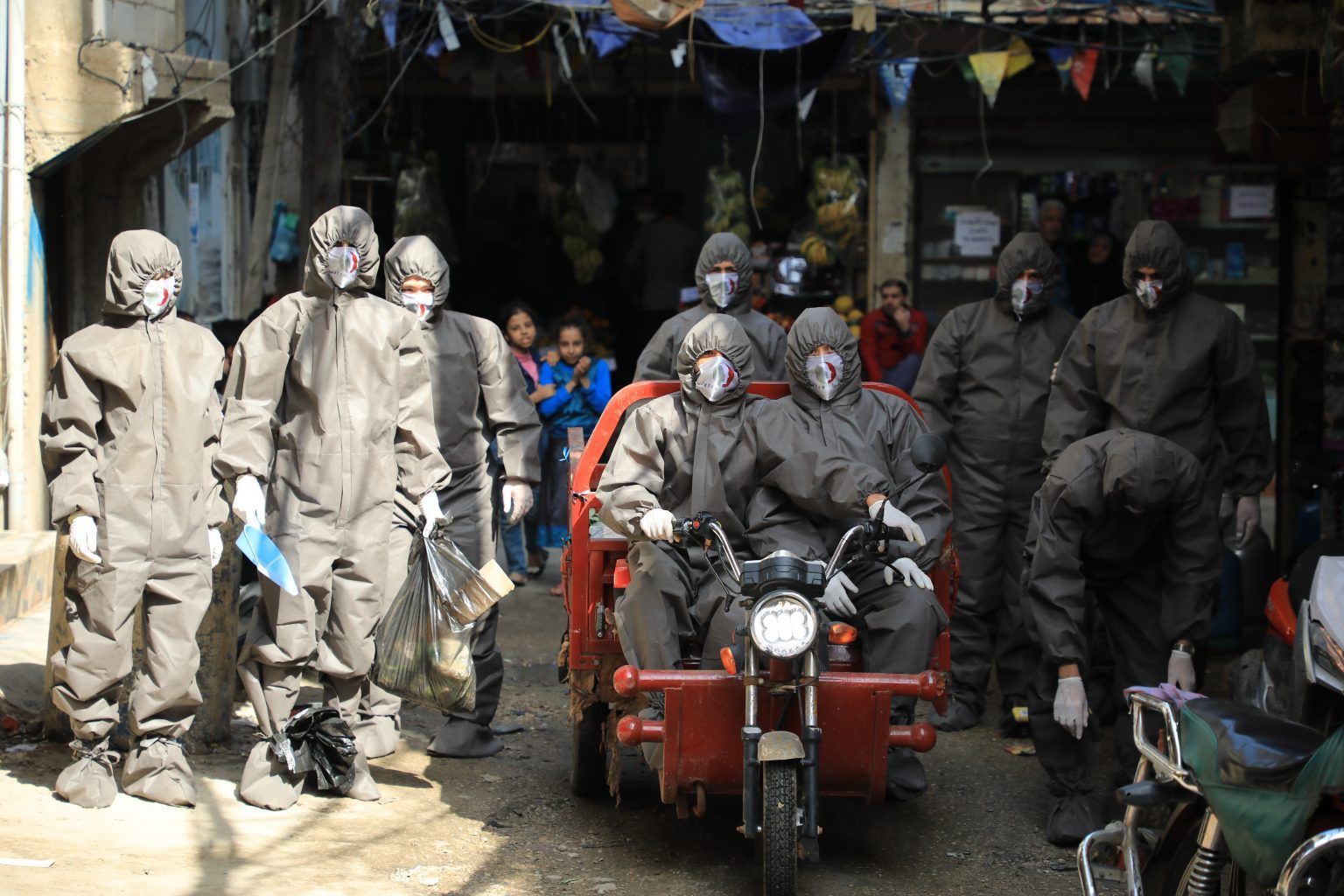 A group of people wearing gas masks are riding a motorcycle.