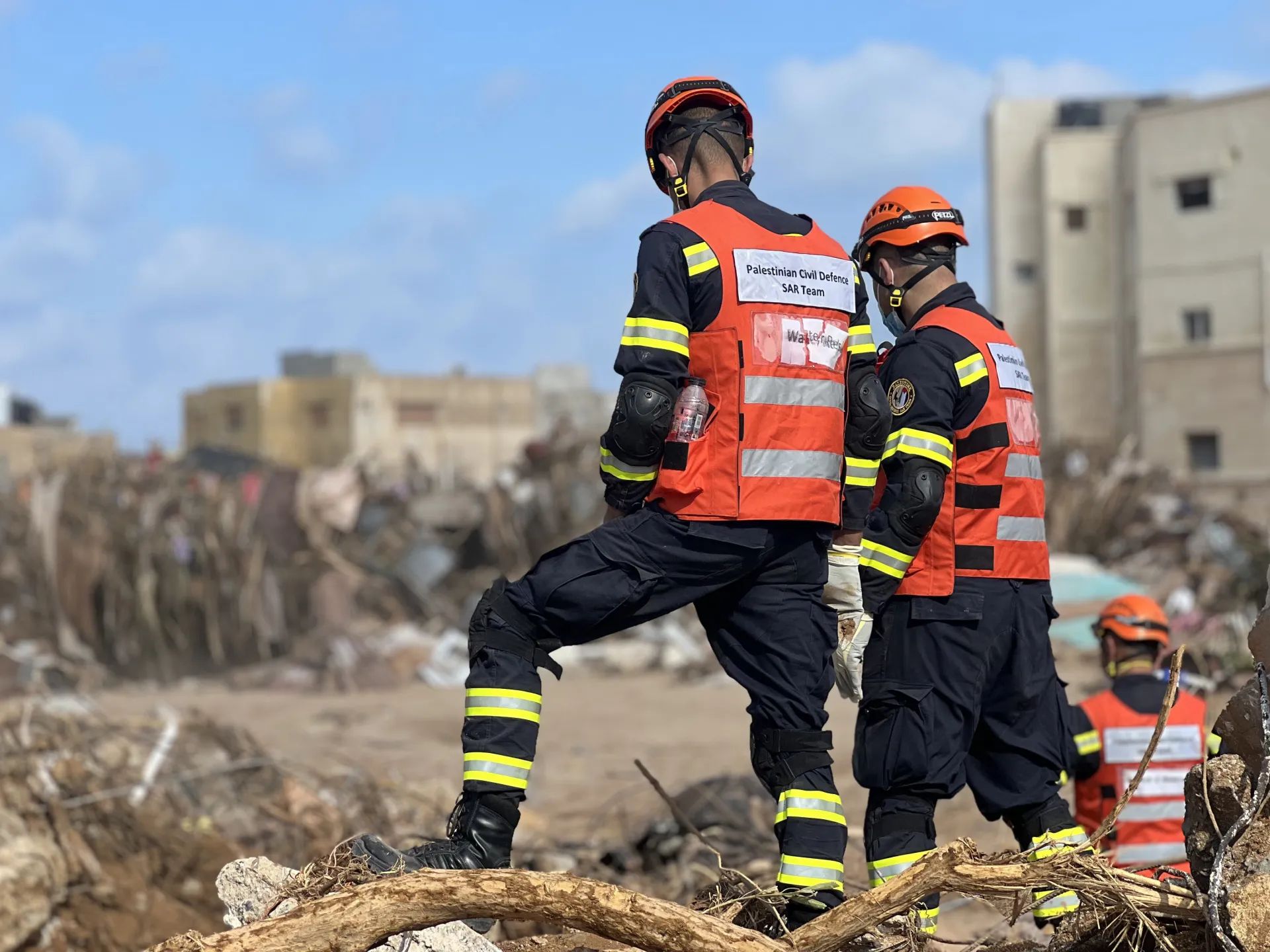 A group of firefighters are standing next to each other in a field.
