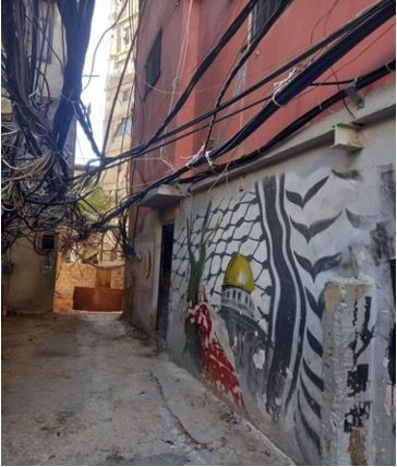 A narrow alleyway with graffiti on the side of a building