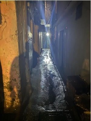 A dark alleyway between two buildings at night.