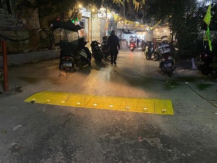 A group of people are walking down a street at night.