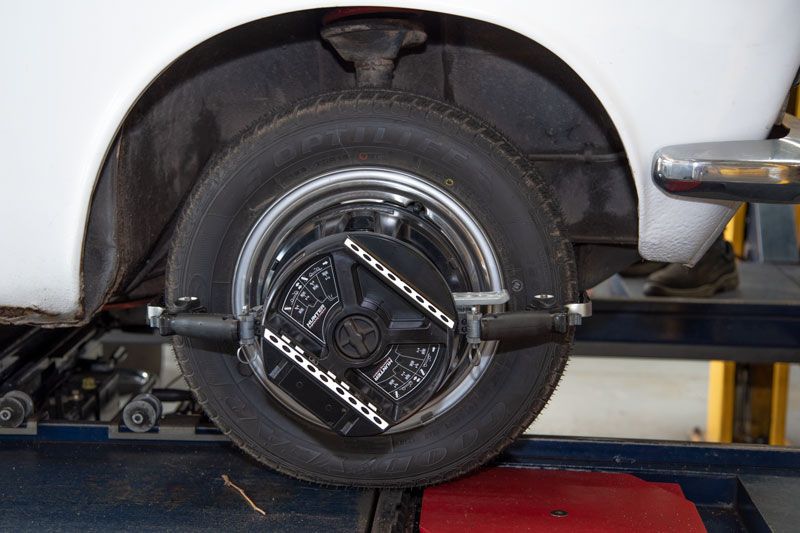 Close-up of a car wheel on a dynamometer, with a metal testing rig attached.