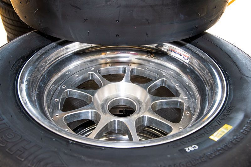 Stacked car tires with a shiny chrome wheel rim close-up