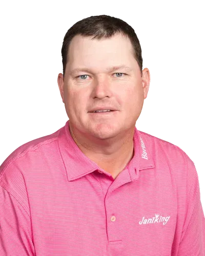 Portrait of a man in a pink polo shirt against a white background