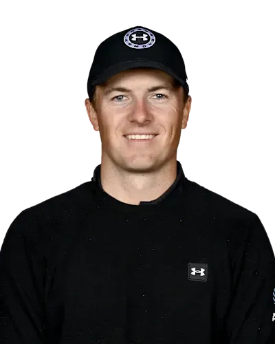 Portrait of a man in a black cap and black sweater, smiling against a white background