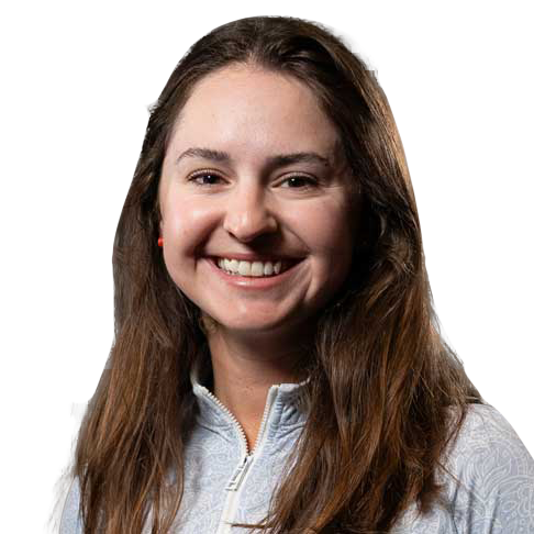 Smiling woman with long brown hair in a white zip-up top against a white background