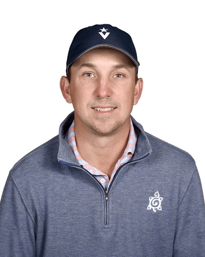 Head-and-shoulders portrait of a man in a navy cap and gray zip-up pullover, smiling against a white background