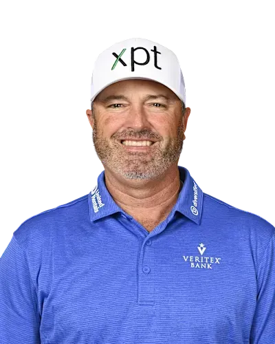 Smiling man in a blue polo and white XPT cap, posing against a white background.
