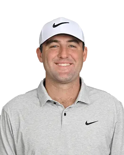 Smiling man in a gray polo and white cap against a plain white background
