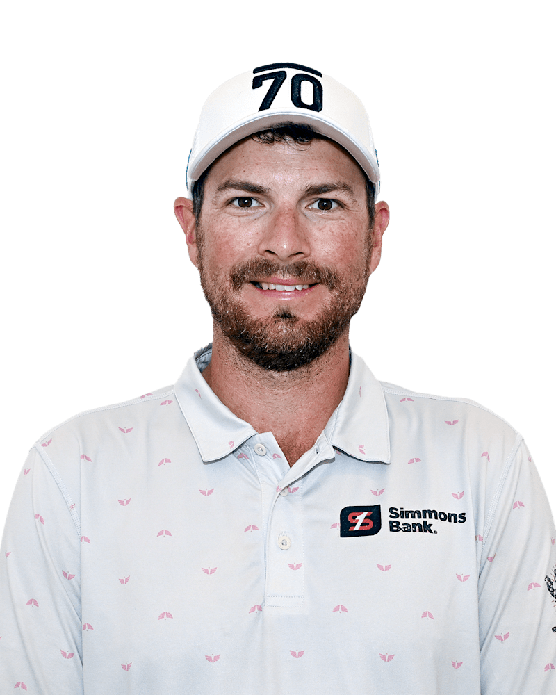 Man in white cap and polo shirt with sponsor logos, facing forward and smiling.