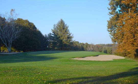 A golf course with a sand trap in the middle of it