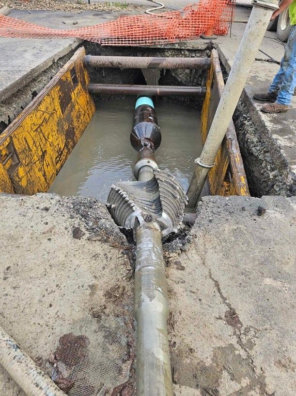 A yellow pipe is laying on the ground next to a truck.