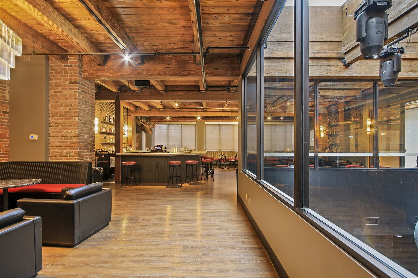 A large room with a lot of windows and a brick wall.