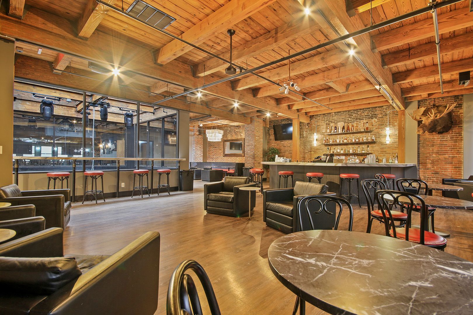 A large room with tables and chairs and a bar.