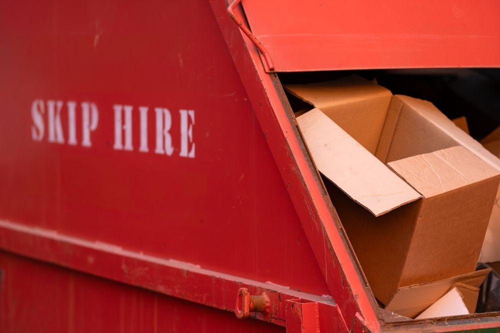 Red skip bin filled with cardboard boxes and waste — UBIN in Broadwater, NSW