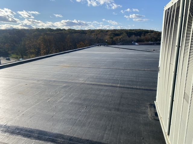 A black roof with a white air conditioner on it