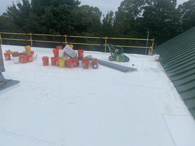 A roof with buckets and a lawn mower on it.
