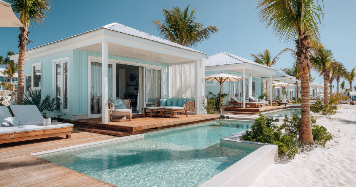 Beachside bungalows with private pools, light blue siding, white trim, and palm trees.