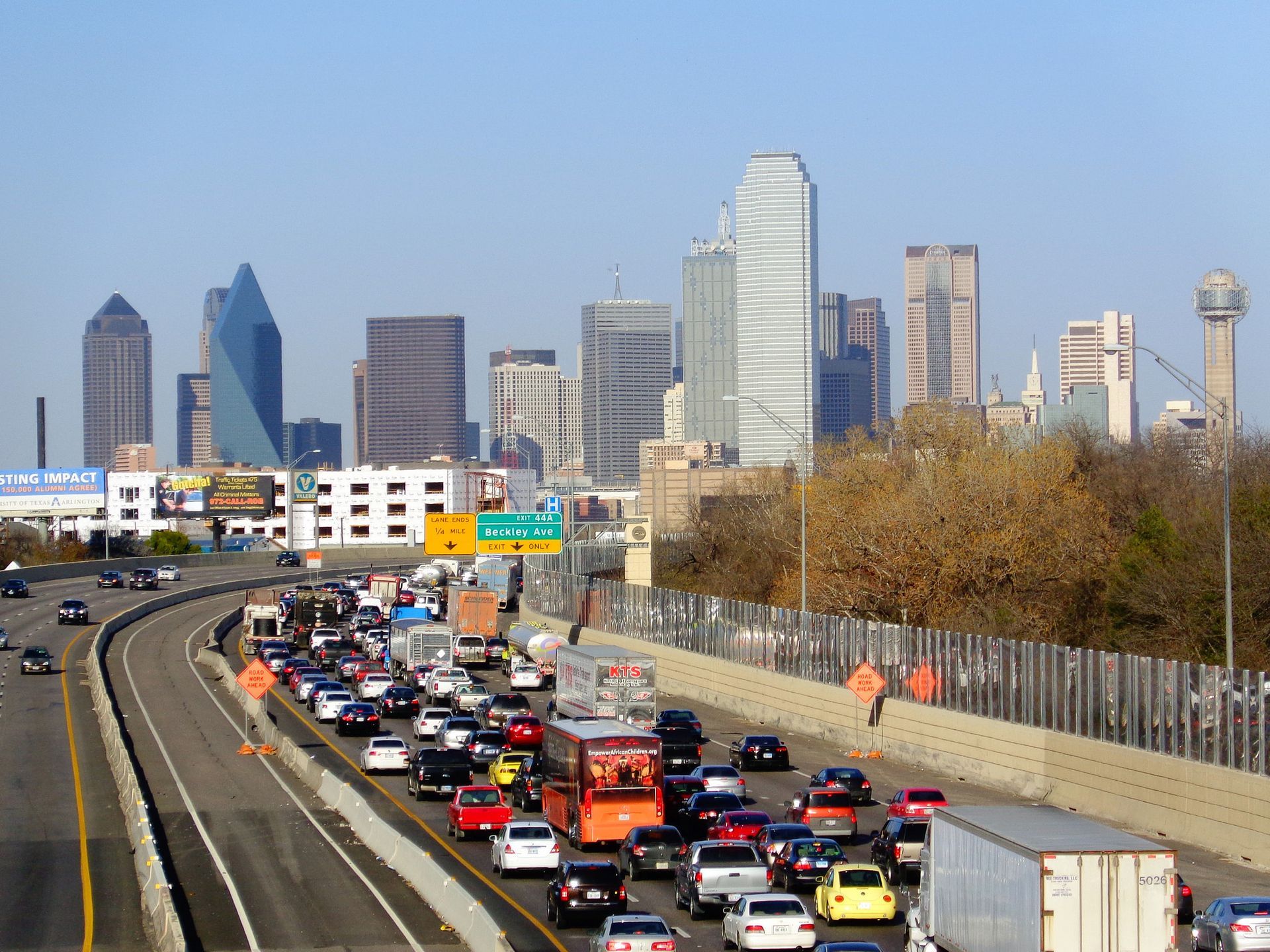 Dallas skyline over I-35 traffic at rush hour ,dense cars and trucks on the highway. 
