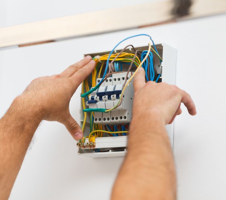 Electrician Man Installing Electric Fuse At Home — 7E Integrated Services In Newcastle NSW