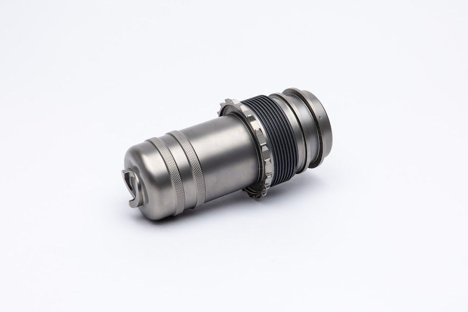 Metallic, cylindrical device with intricate details, possibly a component.