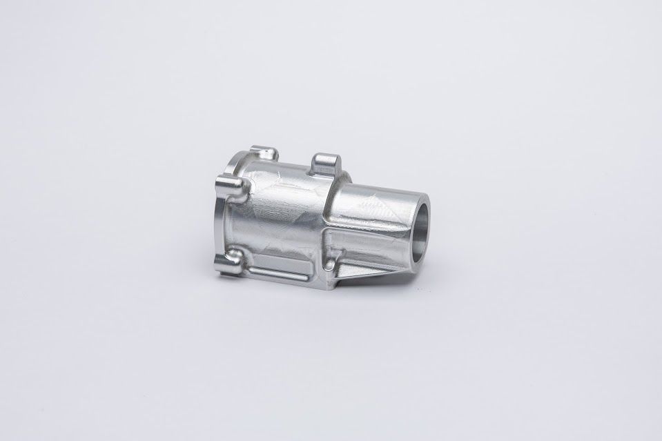 Silver metal hose coupling on a white surface.