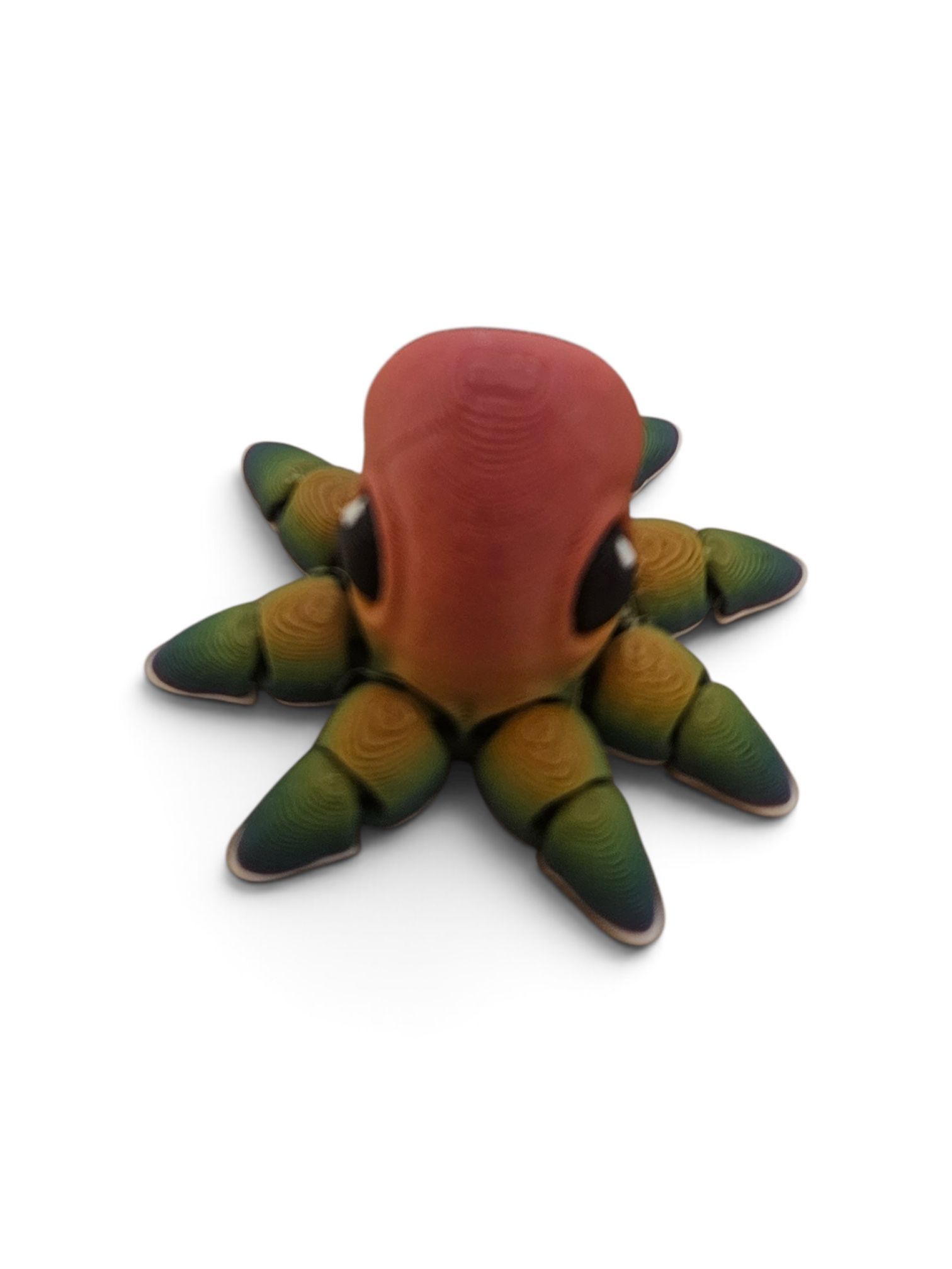 Small colorful octopus figurine with a red head and green-yellow tentacles on a white background