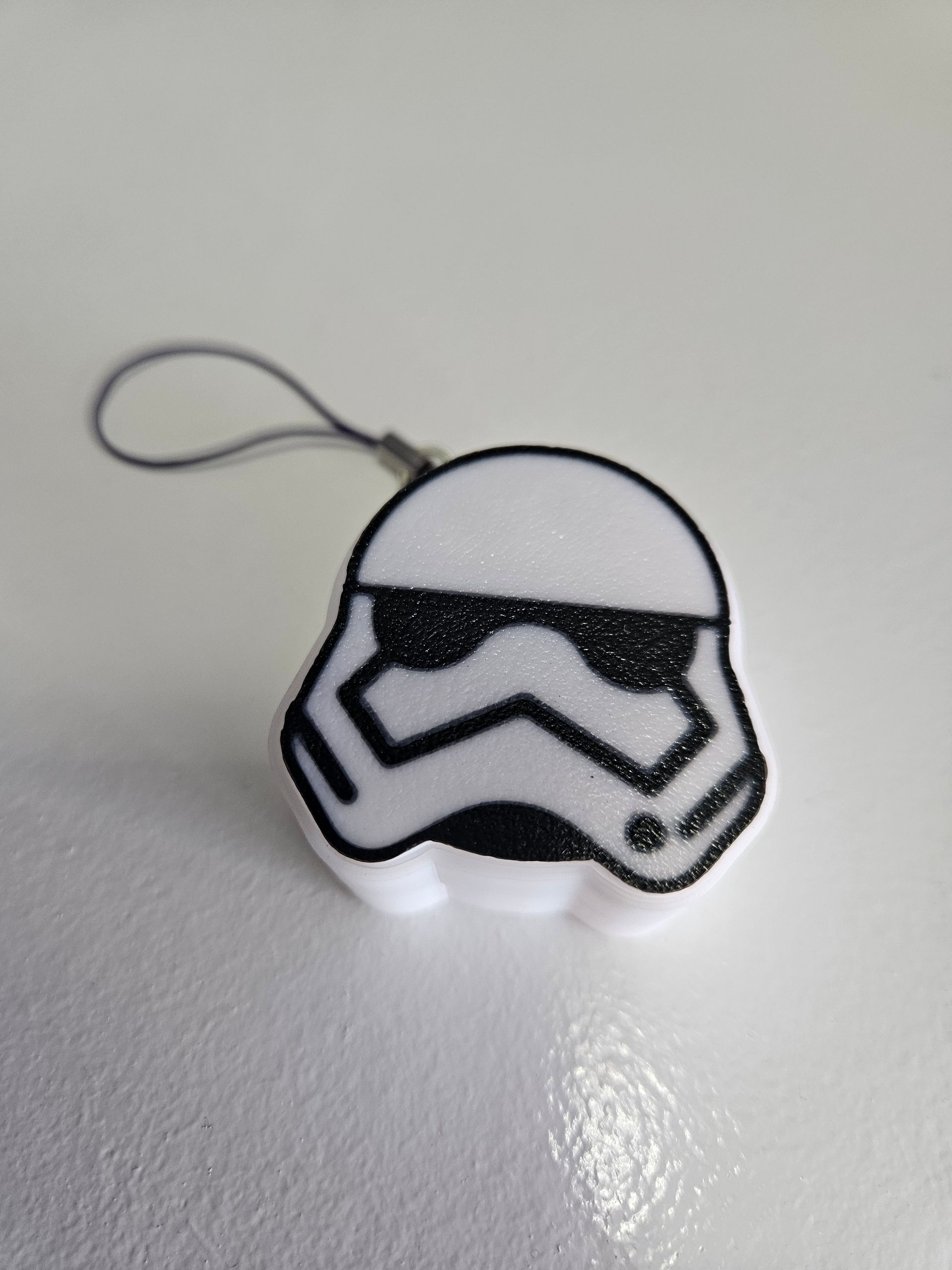 Small Stormtrooper-shaped keychain charm on a white surface.