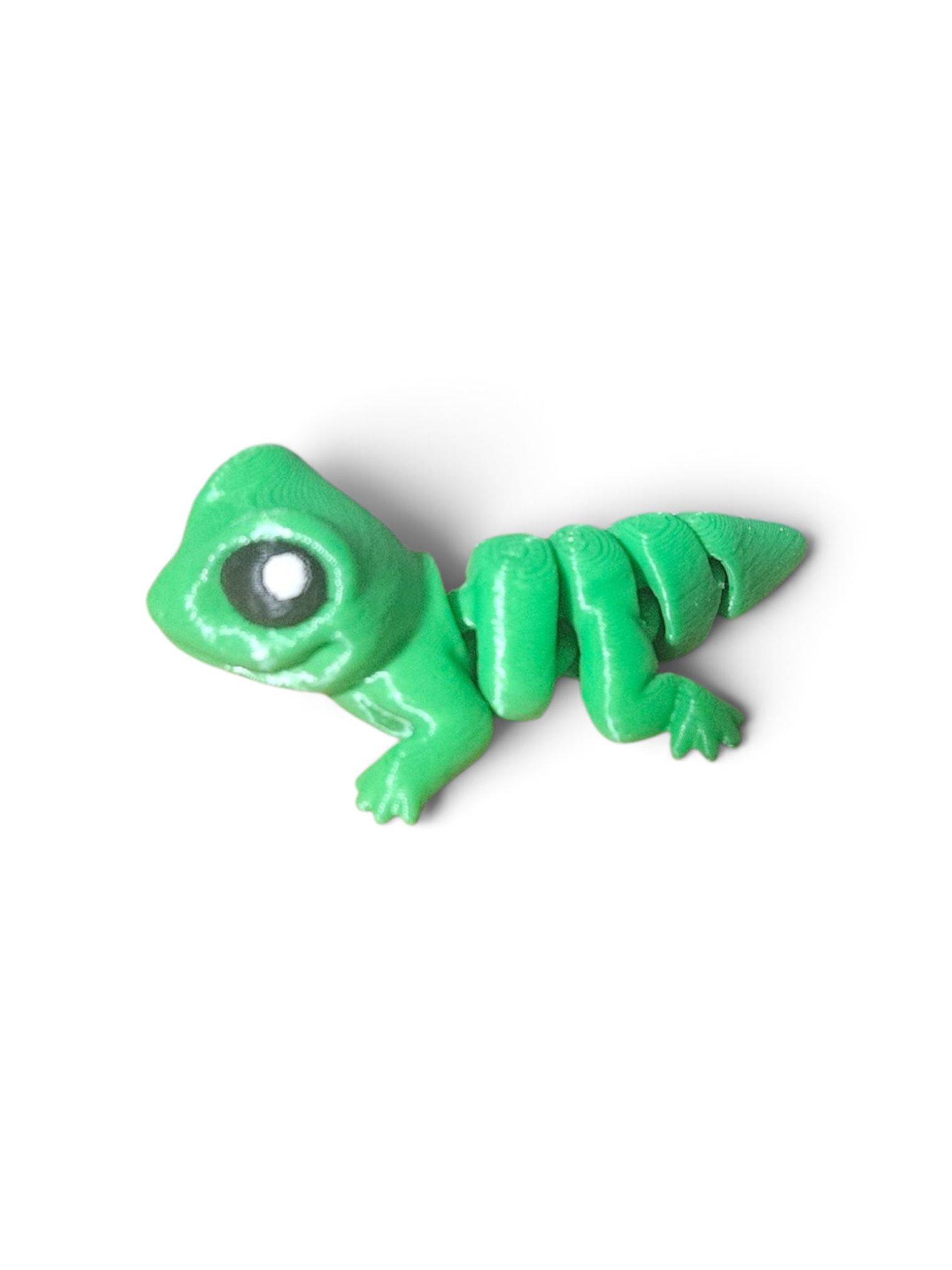 Small green cartoon dinosaur figurine on a white background
