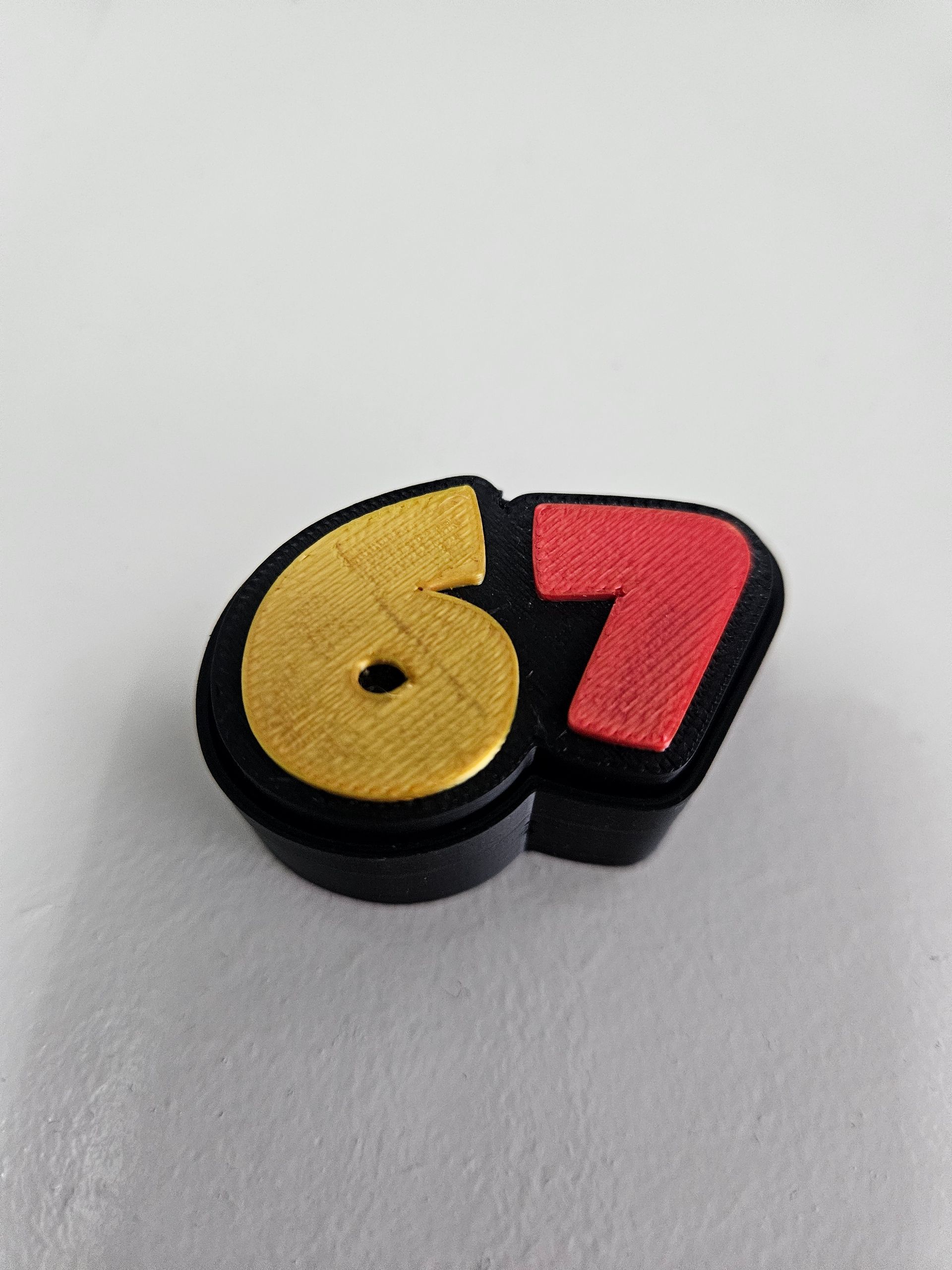 Yellow and red “67” patch on a light background