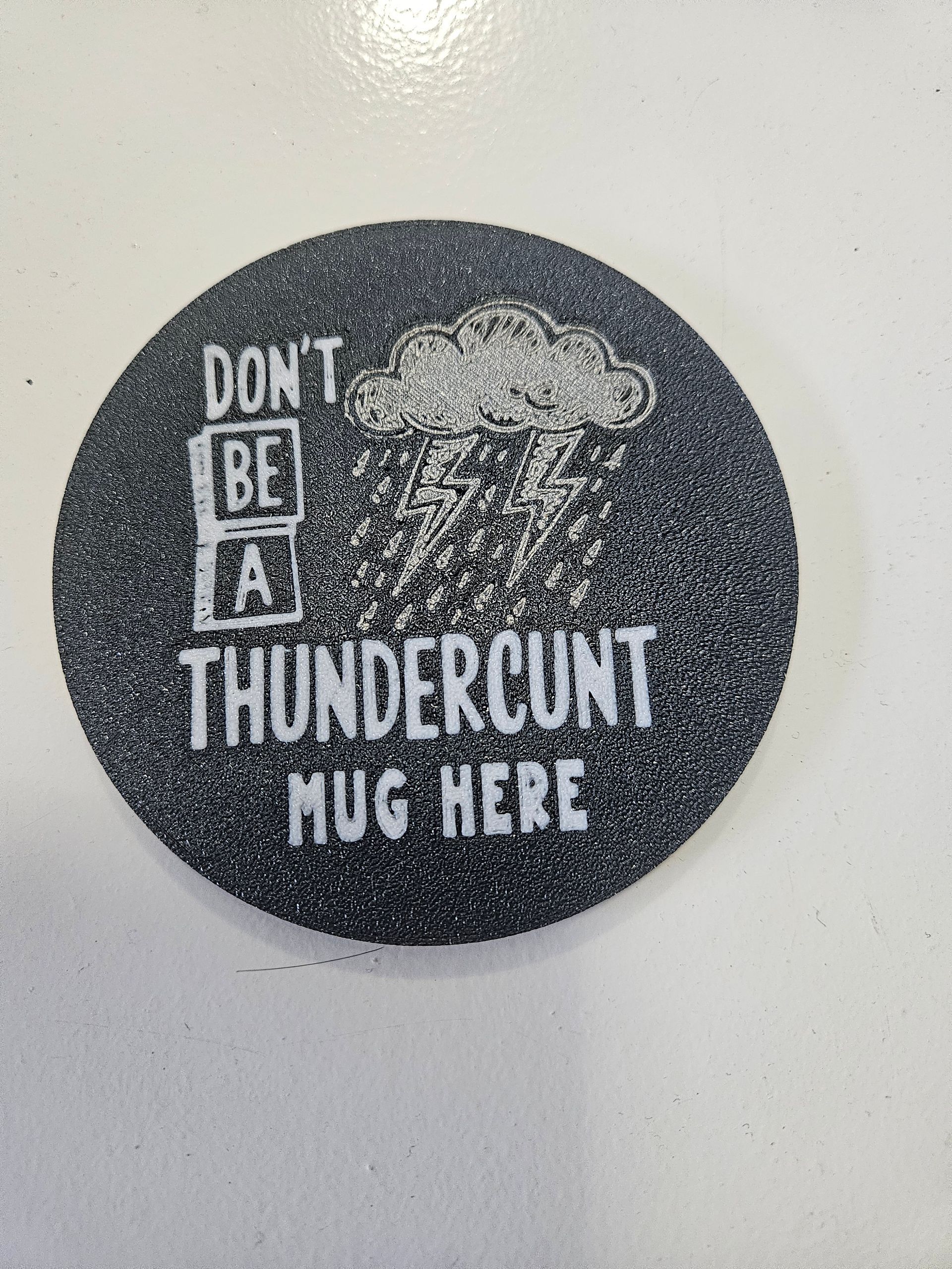 Black glittery coaster with white text:
